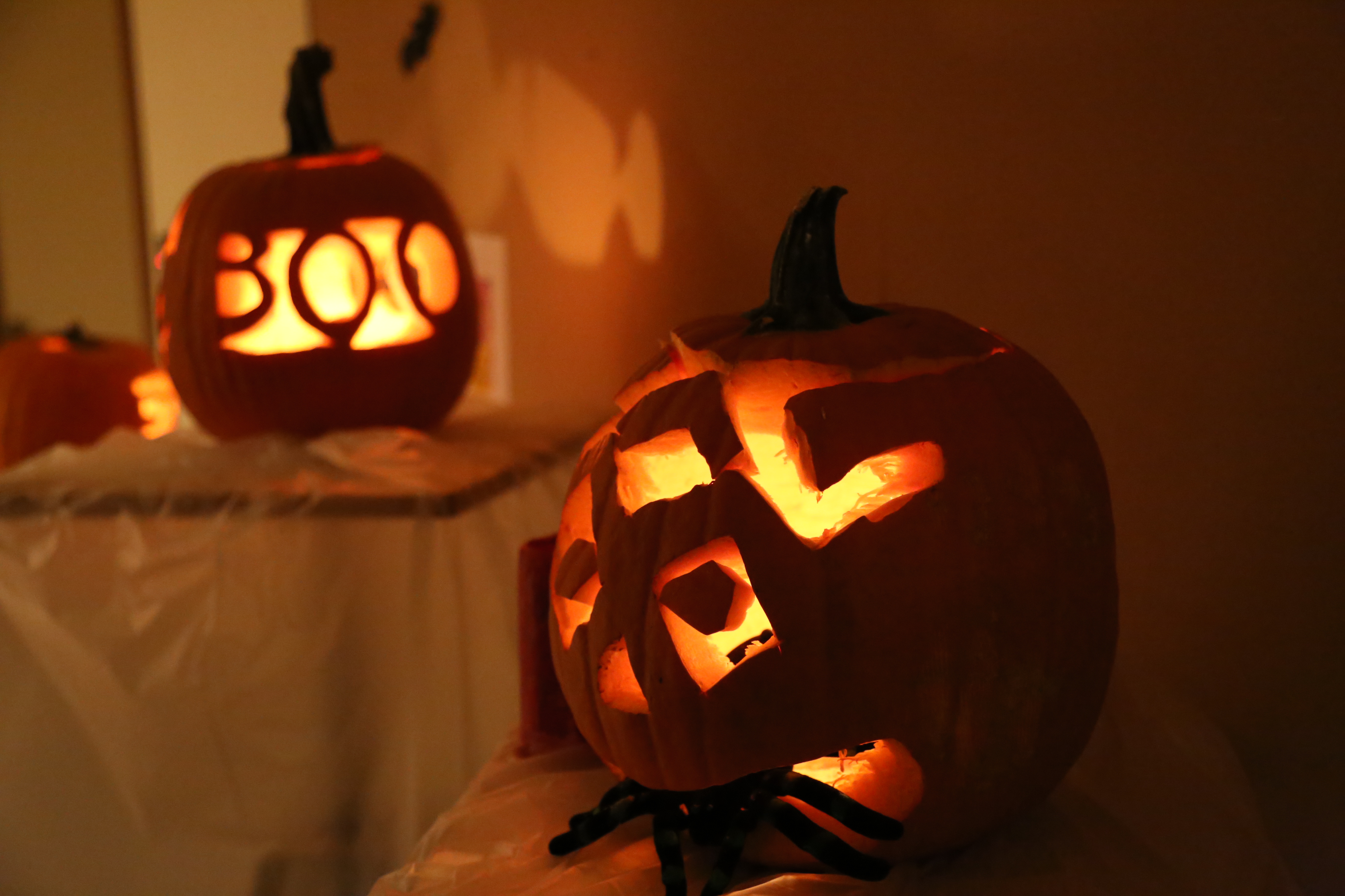 Two scary pumpkins sitting side by side
