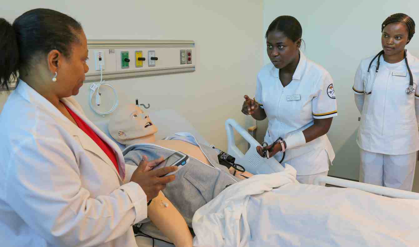 Students Working with Professor in Nursing Simulation Lab