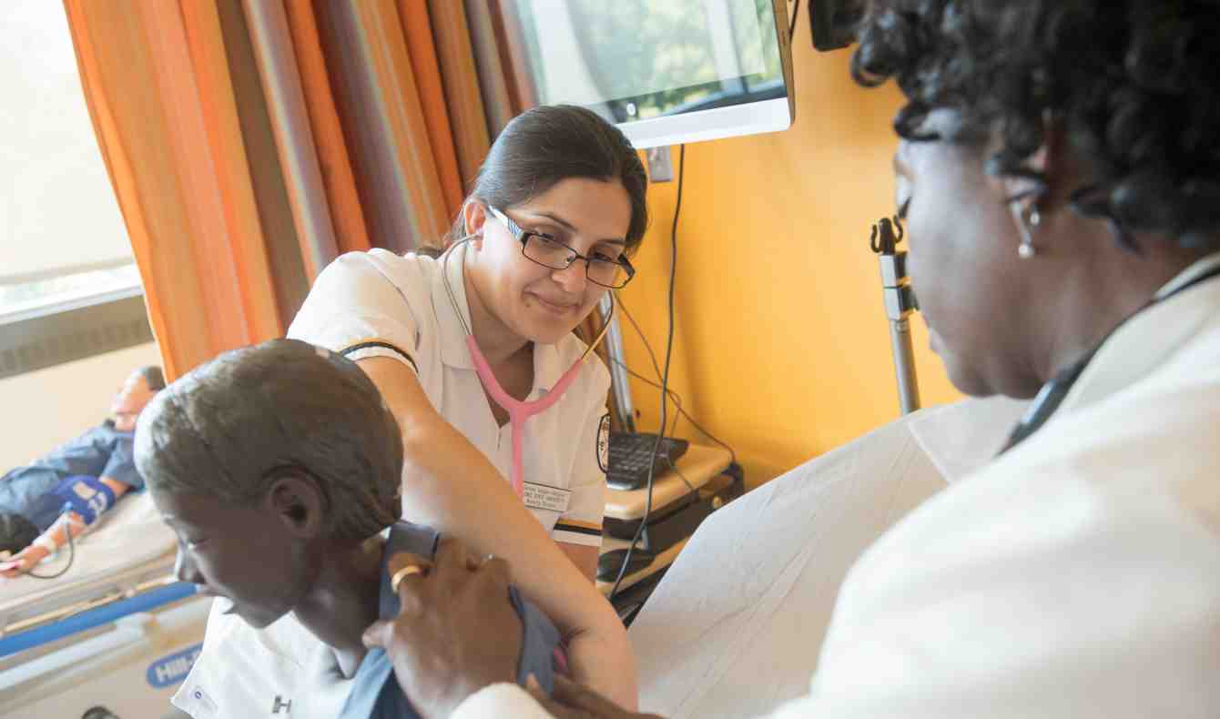 Students Working with Professor in Nursing Simulation Lab
