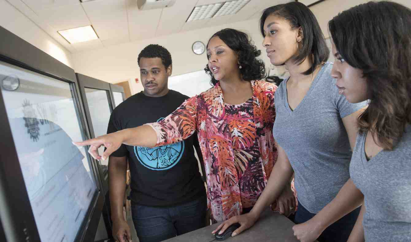 Diverse Students Stand with Professor Around a Computer Screen